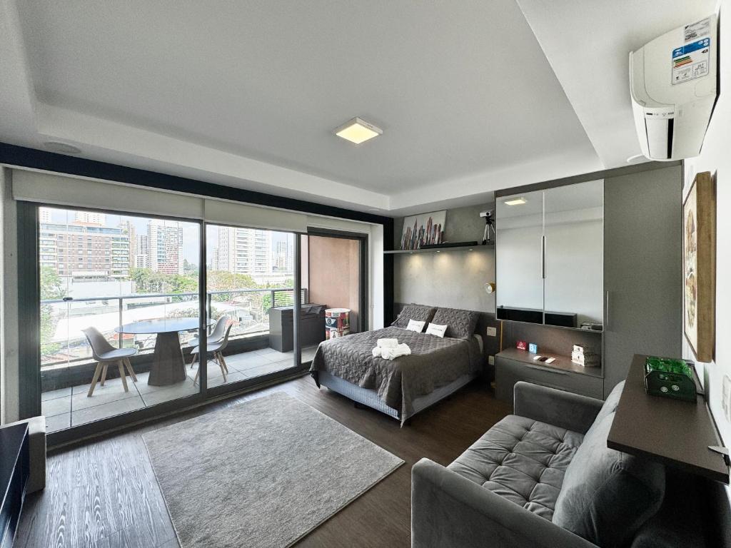 a living room with a couch and a bed at Yalla Stay - Cool Studio Habitarte in Sao Paulo