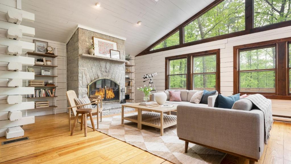 ein Wohnzimmer mit Couch und Kamin in der Unterkunft Half Moon by AvantStay 4BR Cabin w Large Deck Yard w Patio Outdoor Dining in Great Barrington