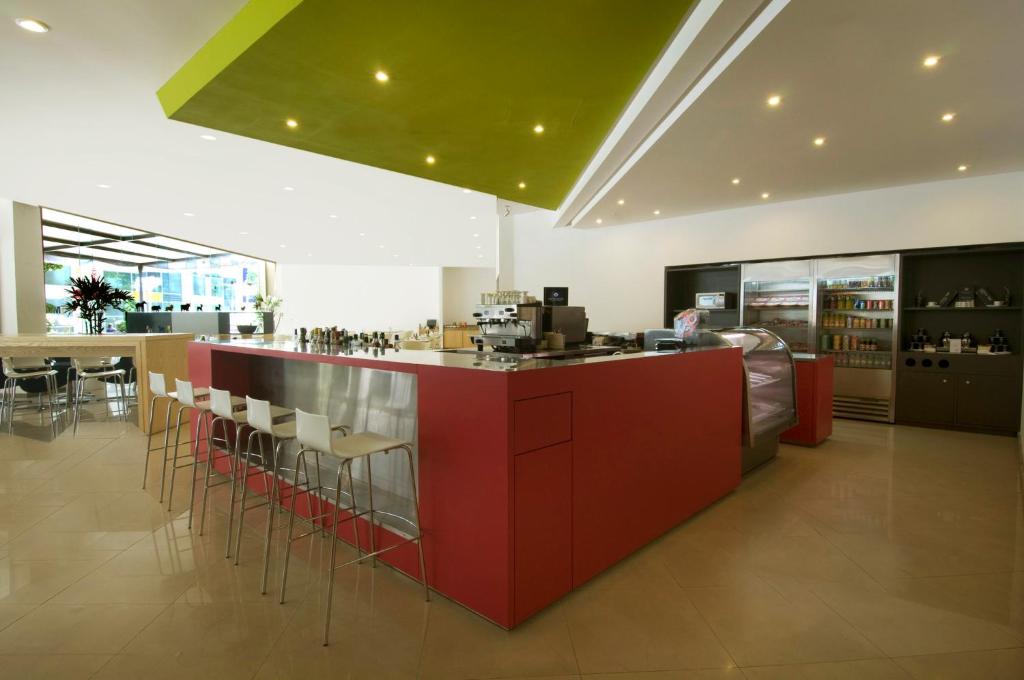 A red service counter anchors a bright café-style food and drink area.