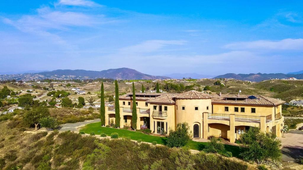 a large house on top of a hill at Palazzo Del Sol By AvantStay Breathtaking Home w Mountain Views Hot Tub in Temecula