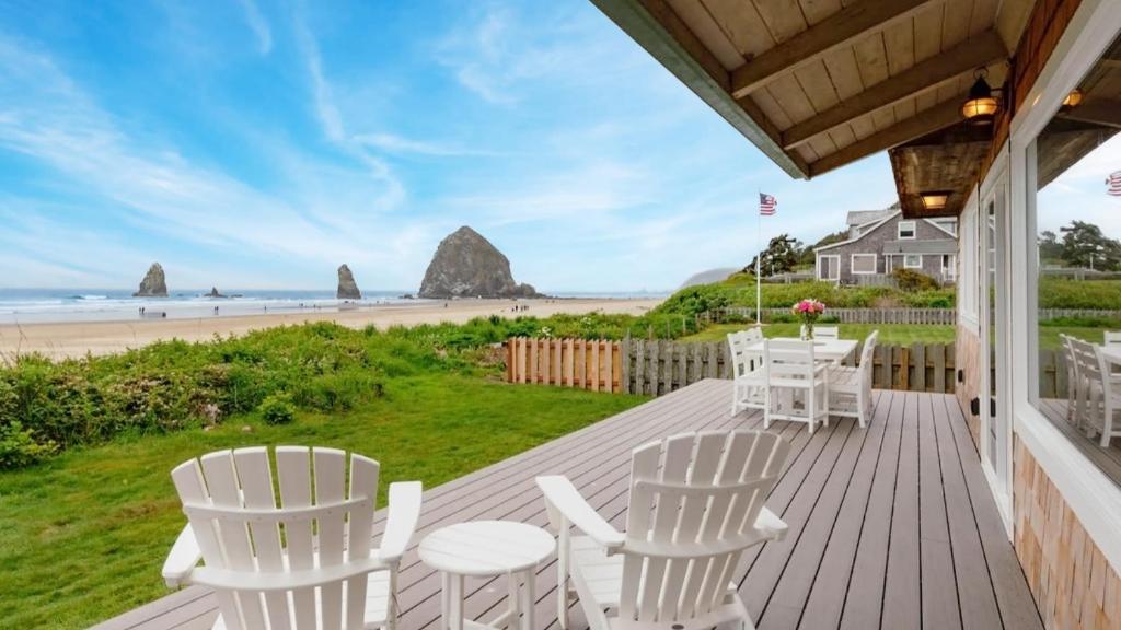 - une terrasse couverte avec des chaises blanches et une vue sur la plage dans l'établissement Driftaway by AvantStay Direct Cannon Beach Access w Stunning Views, à Cannon Beach