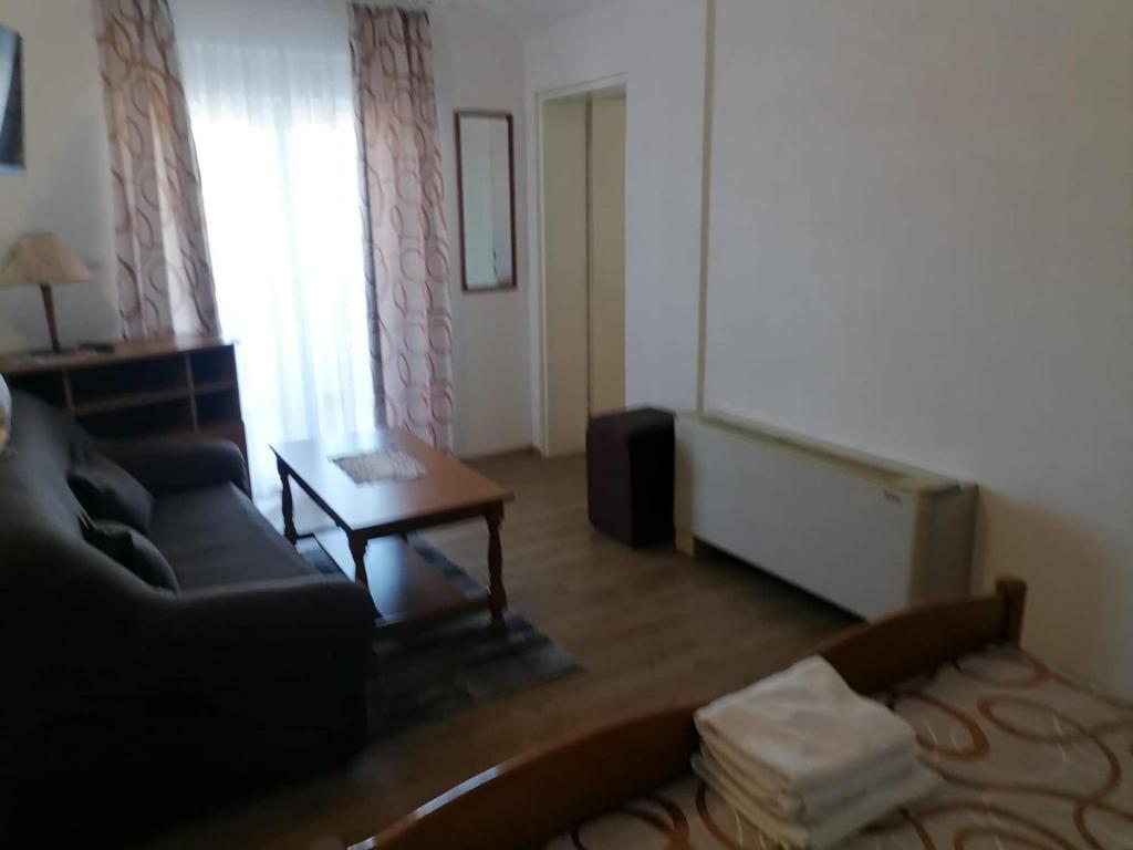 a living room with a couch and a table at Apartments Libertas - Studio with Balcony and Sea View - 3 in Rogoznica