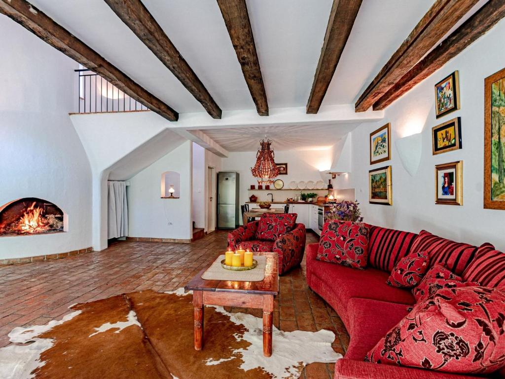 a living room with a red couch and a table at Stone House Anfitrite - Two Bedroom Villa with Private Pool and Terrace in Trstenik