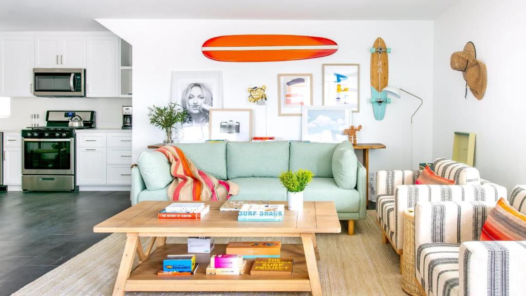 a living room with a blue couch and a table at ONeill I by AvantStay Coastal Paradise Steps from Beach Modern Decor in Newport Beach
