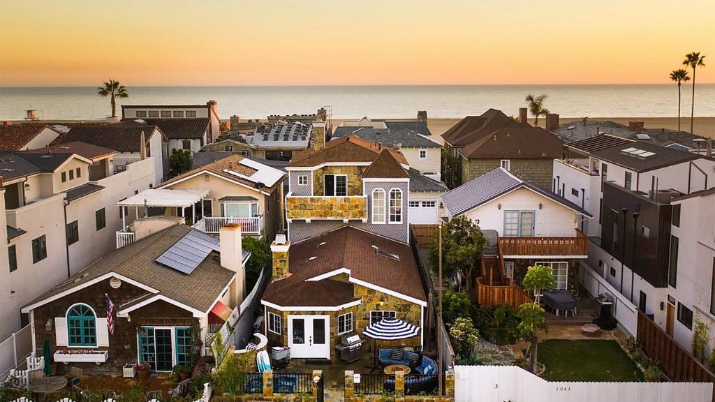 Una vista aérea de un pueblo con casas y el océano. en Sand Castle by AvantStay Beach House on Balboa Peninsula w Patio Hot Tub, en Newport Beach