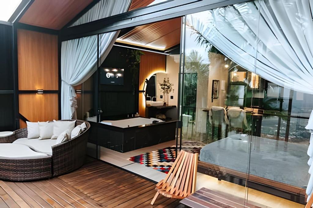 a living room with a couch and a tub at Cabana Vista Ilha/Santo Amaro da Imperatriz in Santo Amaro da Imperatriz