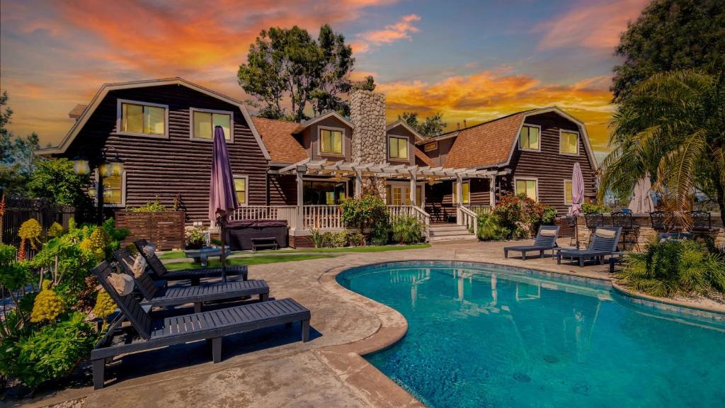 a house with a swimming pool in front of a house at Chateau Syrah by AvantStay Picturesque Estate w Pool Hot Tub Pool Table Table Tennis New Pickleball Court Basketball hoop in Temecula