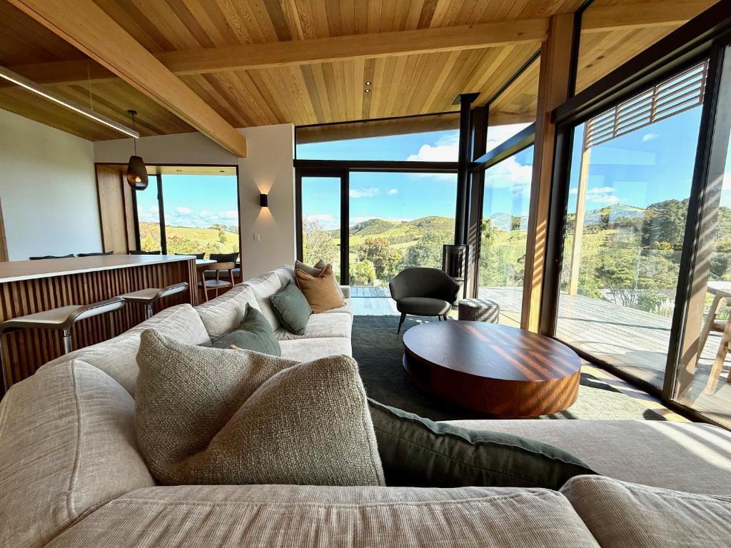 un salon avec un canapé et une table en bois dans l'établissement Obsidian View - Coast & Country, à Putiki
