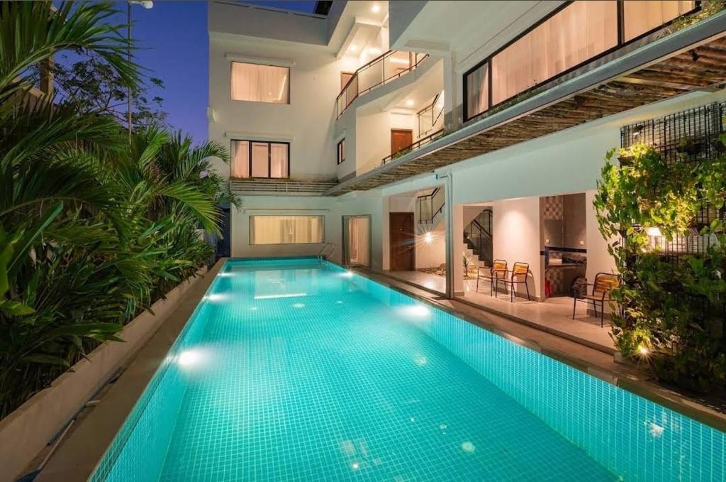 une piscine au milieu d'une maison dans l'établissement Flex Suites, à Phum Pobos