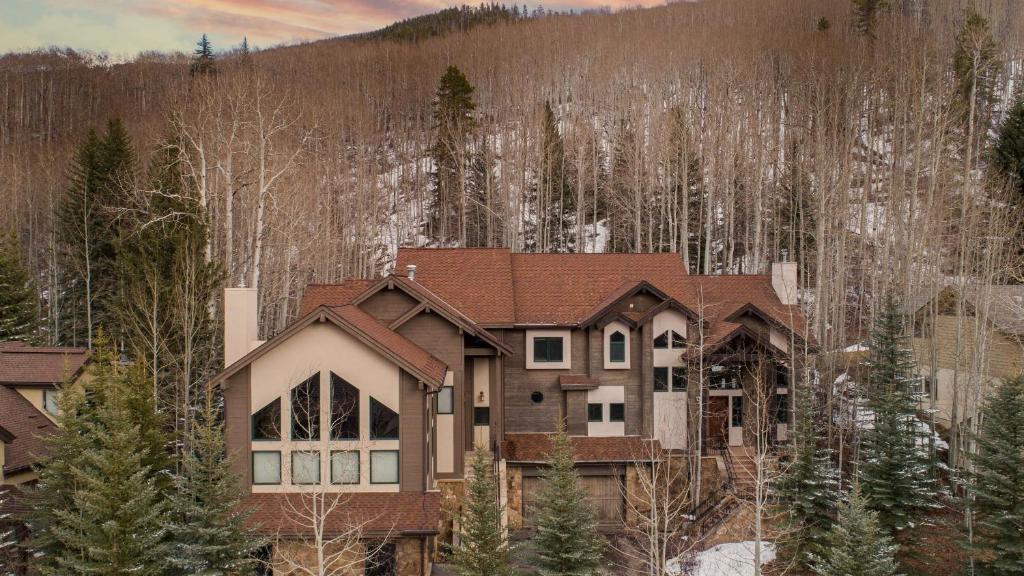 a house in the middle of a forest at Highline by AvantStay Breathtaking Mountain Home w Hot Tub Views in Vail