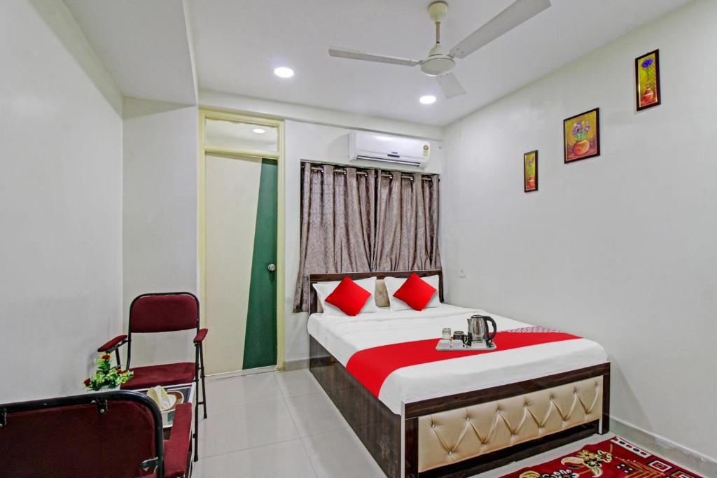 a bedroom with a bed and a chair at Hotel O Sunshine Inn in Nagpur