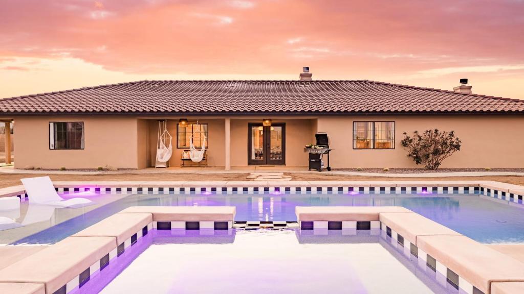 a house with a swimming pool in front of a house at Flora by AvantStay Modern Private Desert Oasis on Large Grounds w Pool Bocce Ball in Yucca Valley