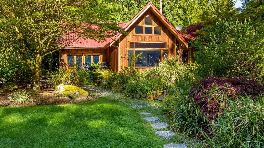 une maison en bois avec un jardin et un chemin dans l'établissement Rhythm Waters by AvantStay Garden Paradise Pond, à Langley