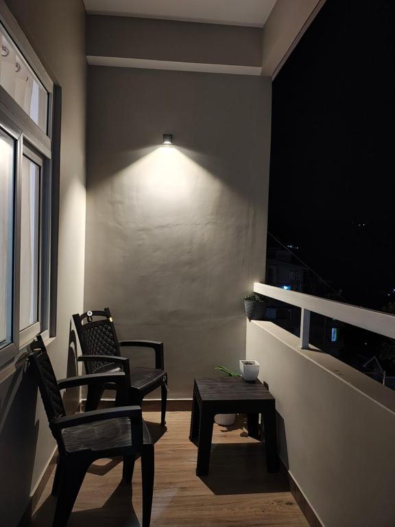 a room with two chairs and a table and a lamp at The Namchi Perch in Namchi