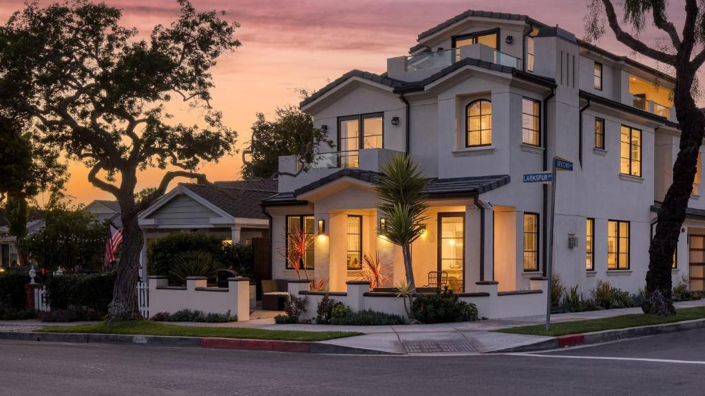 a white house on a street at sunset at Sea Crown by AvantStay 5mins from the Beach w Multiple Terraces PermitSLP13639 in Newport Beach