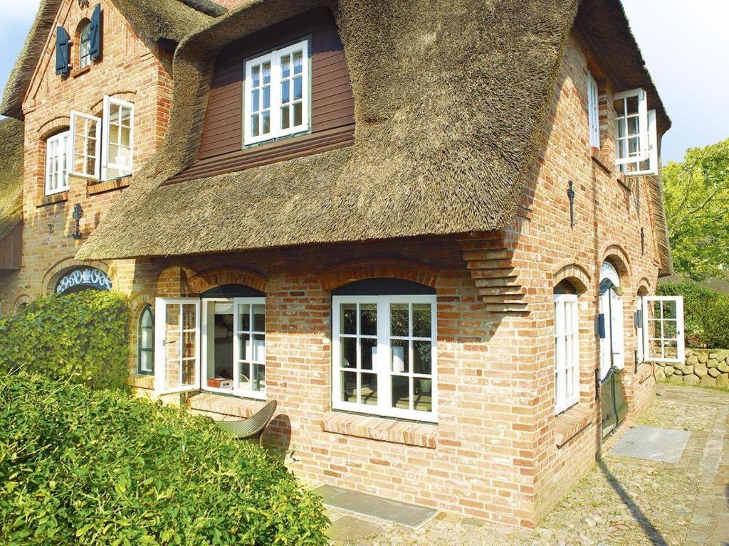 a large brick house with a thatched roof at Vis-a-Vis in Kampen