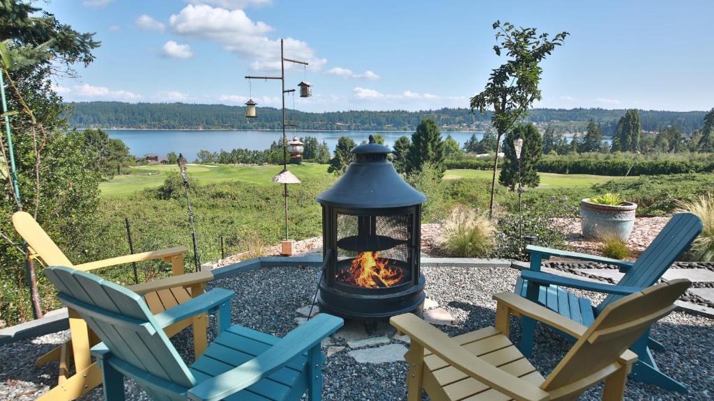 a patio with two chairs and a fire pit at Fairway Harbor View by AvantStay Outdoor Oasis in Freeland