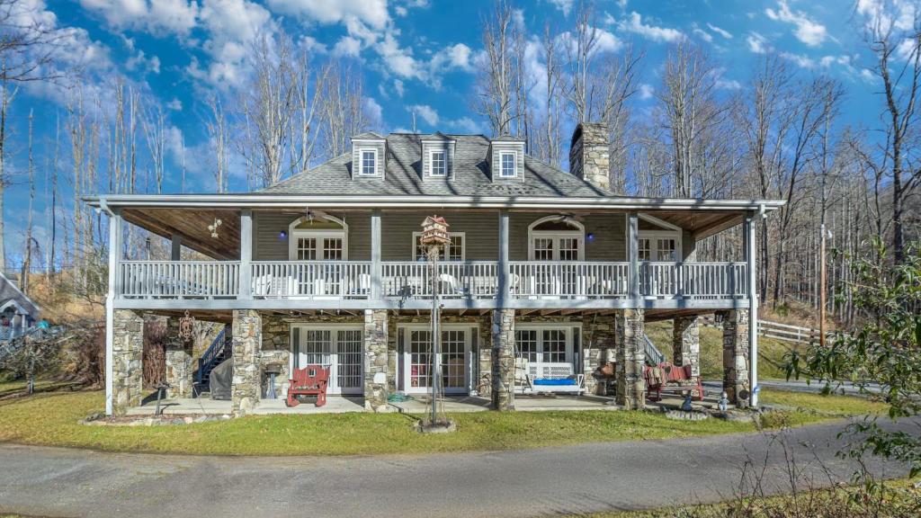 a large stone house with a wrap around porch at Hamersmith Hollow Retreat Estate by AvantStay Great Views in Mars Hill