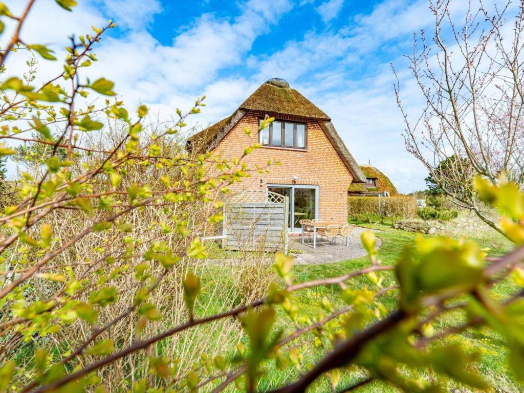 an old house with a thatched roof in a field at Haus-Fahnert-2 in Kampen
