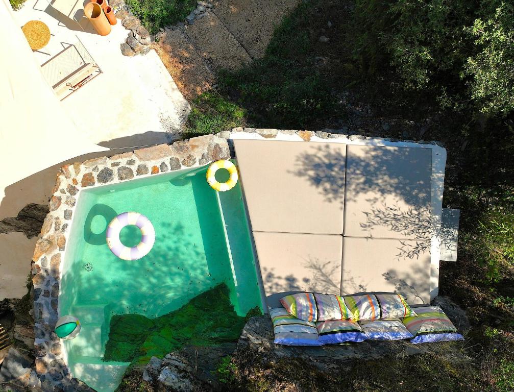 an overhead view of a pool with a door and a couch at Historic Chestnut Kiln With Pool In The Cévennes in Les Plantiers