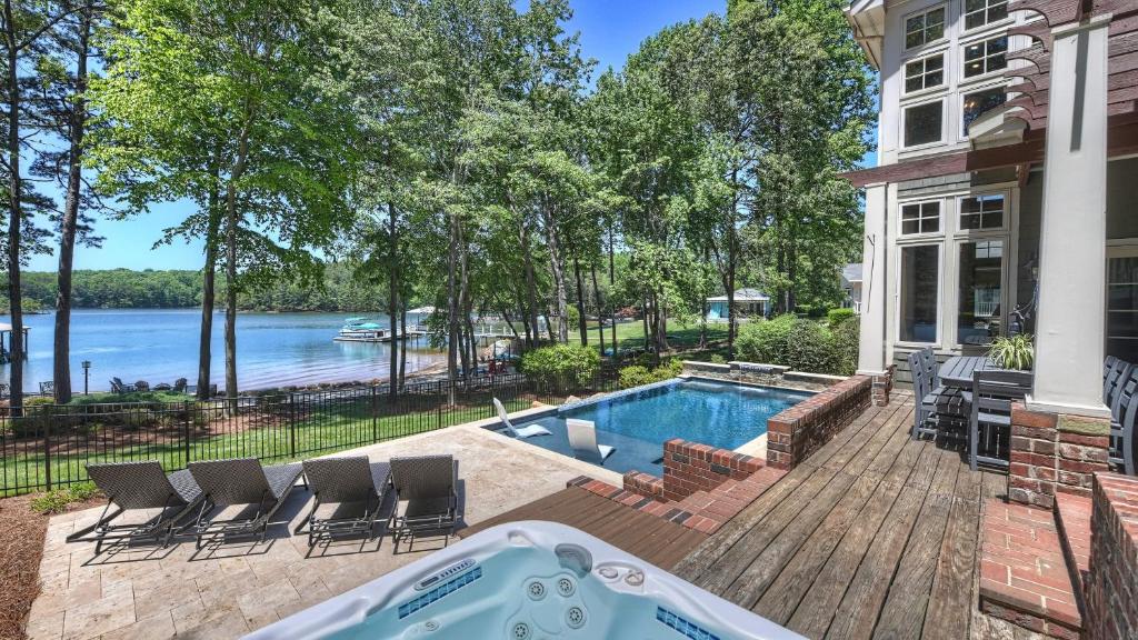 a backyard with a swimming pool and a house at Boathouse Cove by AvantStay Pool Swim Dock Hot Tub in Lake Norman of Catawba