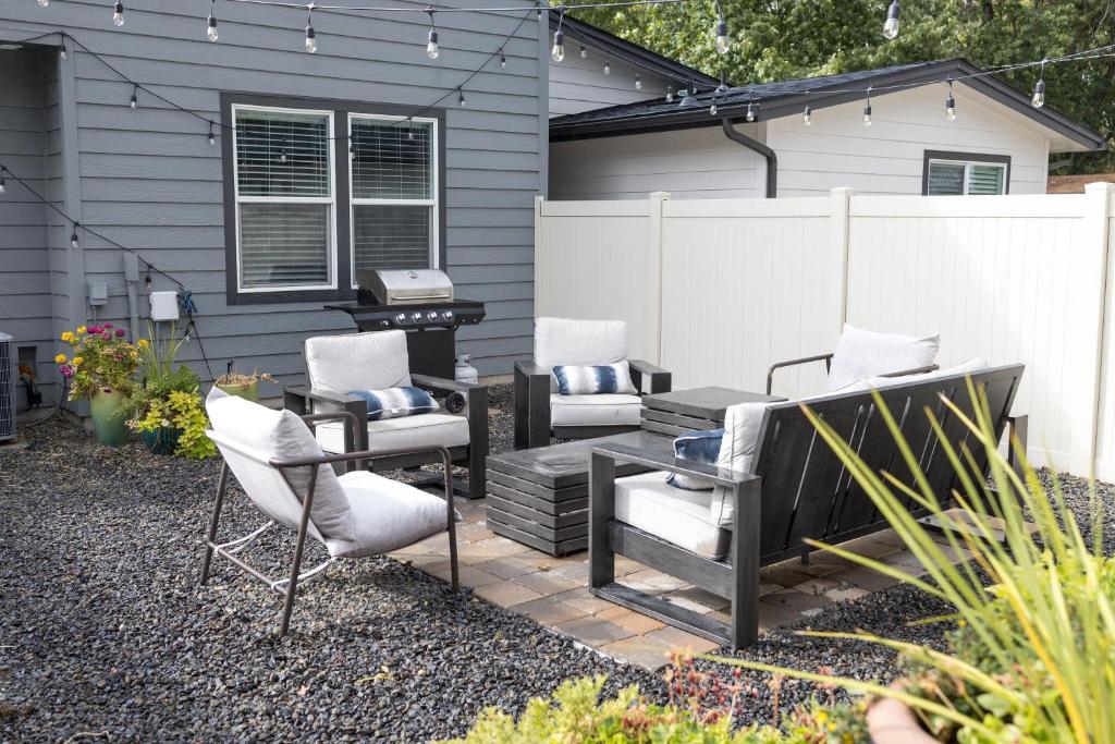 a patio with chairs and a grill in front of a house at North End Blue -Hot Tub - Fire Pit - E Bikes- 4 BR in Boise