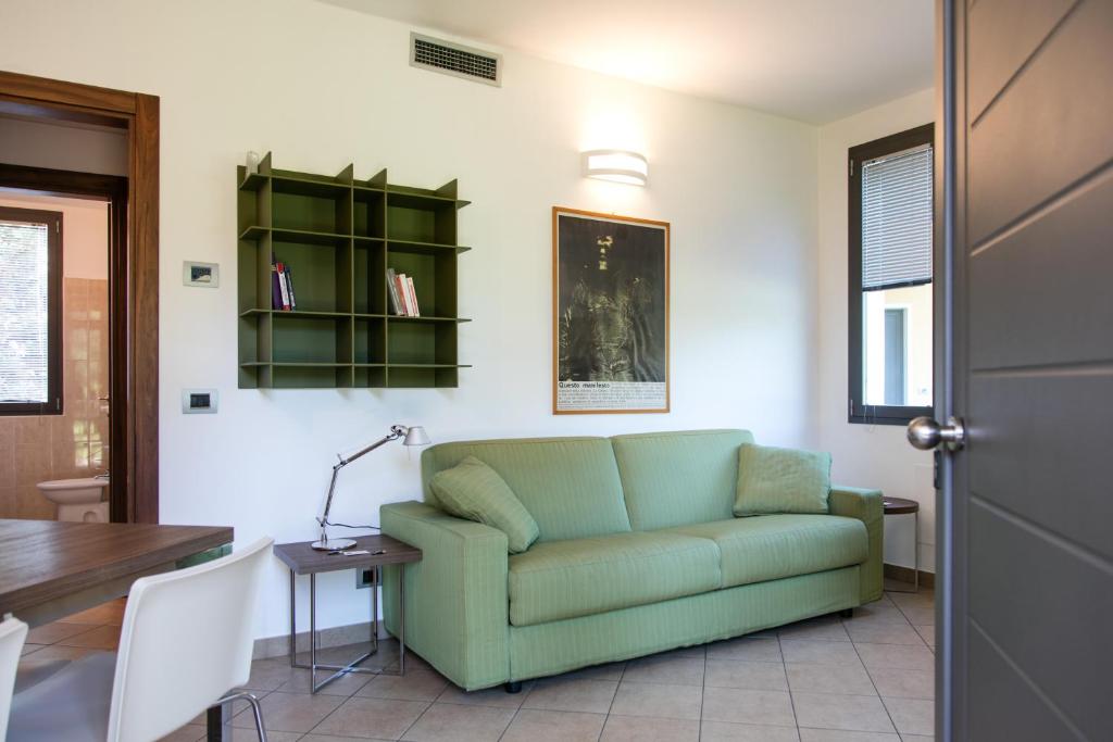 salon z zieloną kanapą i stołem w obiekcie Residenza Del Parco w mieście Vigevano