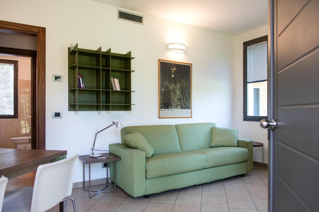 ヴィジェーヴァノにあるResidenza Del Parcoのリビングルーム(緑のソファ、テーブル付)