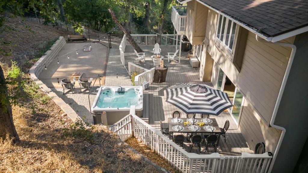 einen Blick über eine Terrasse mit einem Tisch und einem Pool in der Unterkunft Hidden Oaks Farmhouse by AvantStay Hot Tub Deck in Atascadero