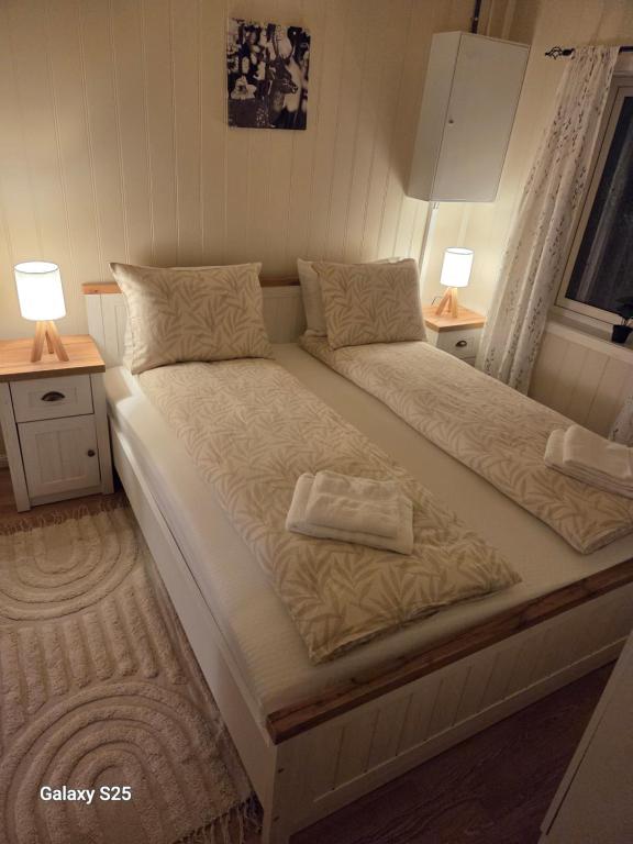 1 cama grande en un dormitorio con 2 lámparas en Auroraheim, en Gryllefjord