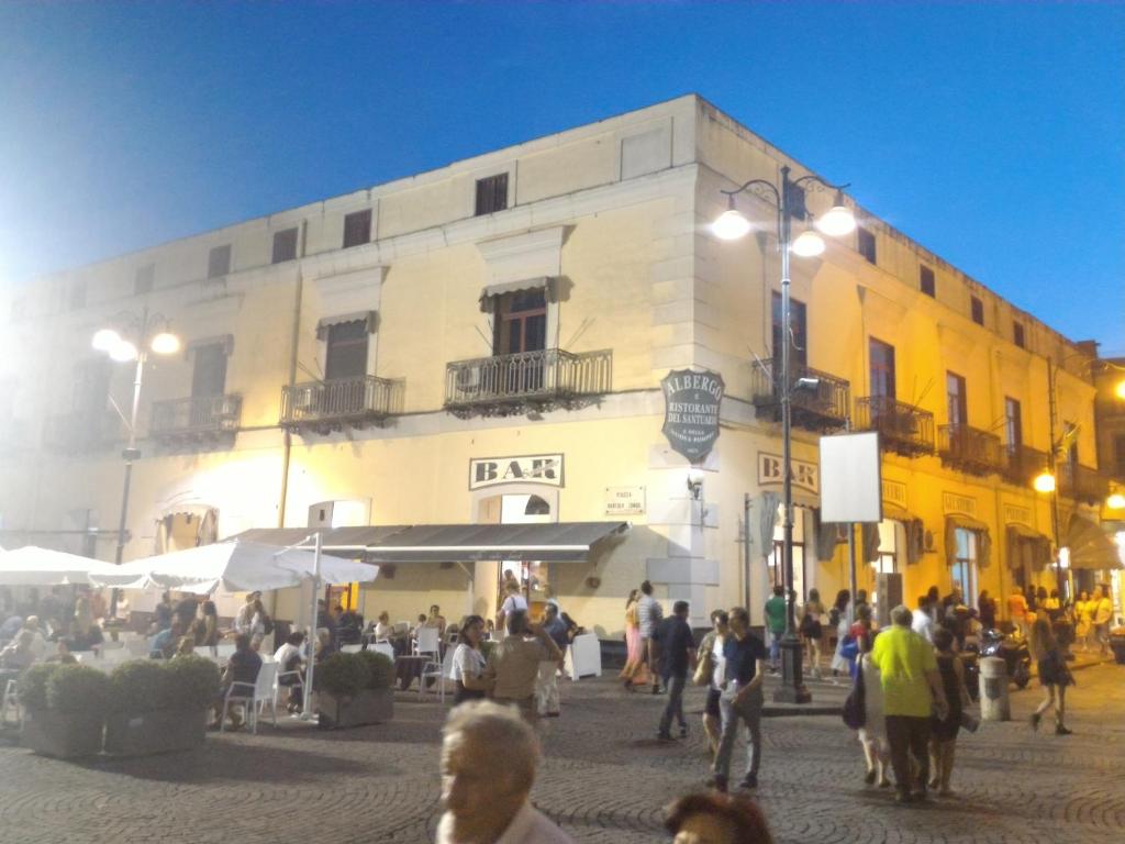 un groupe de personnes marchant devant un bâtiment dans l'établissement Hotel Il Santuario - Pompei, à Pompéi