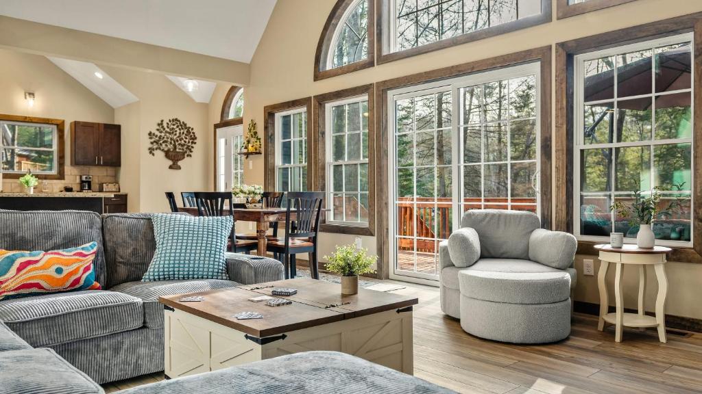 a living room with a couch and chairs and windows at Lakeview Sunset Heaven Waterfront Escape Private Dock Firepit Game Room New Construction in Blakeslee