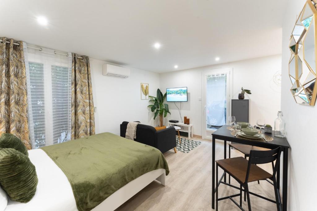 a bedroom with a bed and a desk and a table at Studio 27m² sur la Côte Pavée avec parking privé in Toulouse