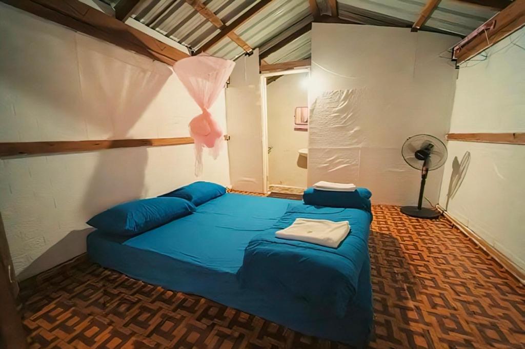 a bedroom with a blue bed in a room at Homestay Nunga หนูหง่าโฮมสเตย์กิกอคอ in Pang Mapha