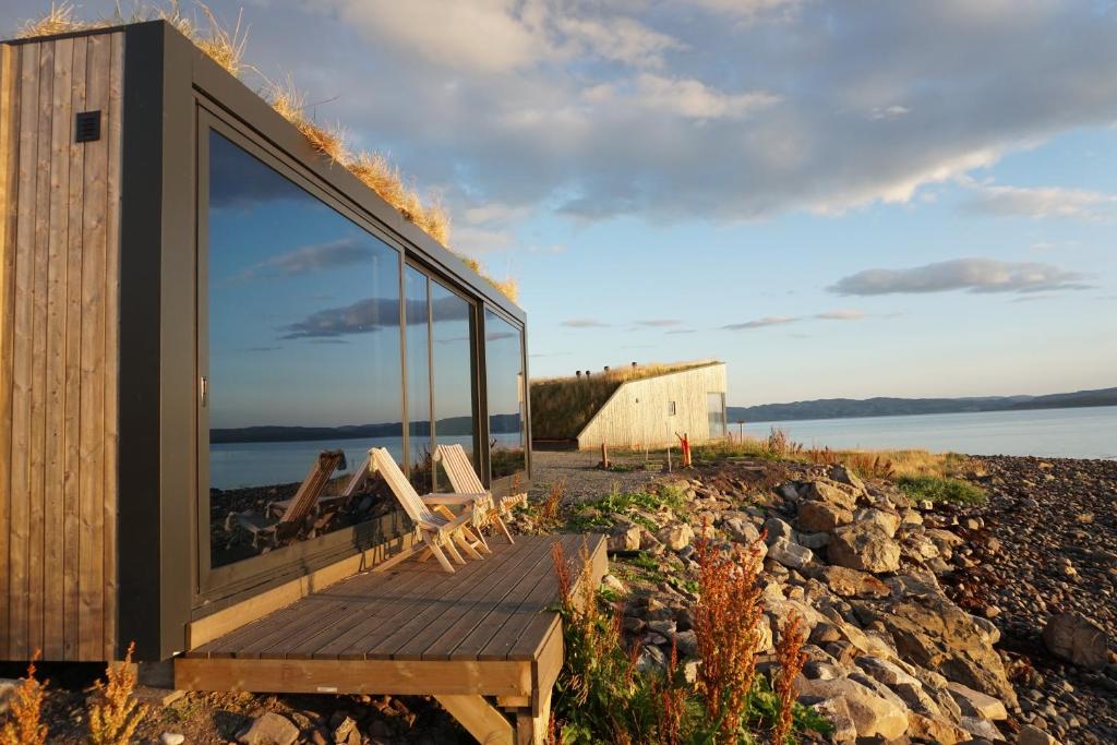 a house with a large window on a beach at Varanger Sea View Mini House in Varangerbotn