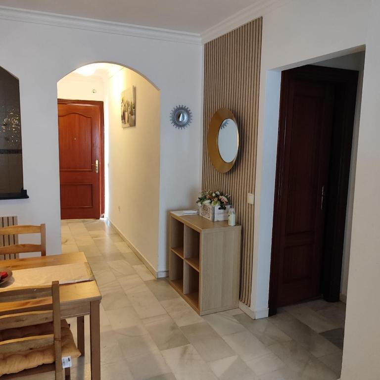 a living room with a table and a mirror on the wall at PUERTO I Playa in Fuengirola