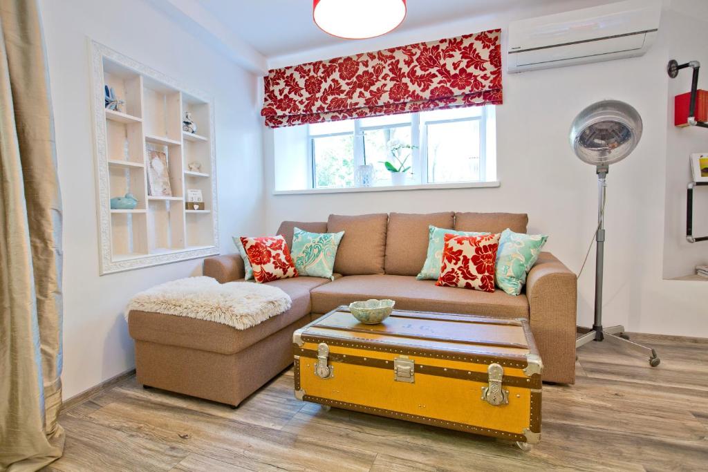 a living room with a couch and a suitcase at Heart of Kalamaja Apartment in Tallinn