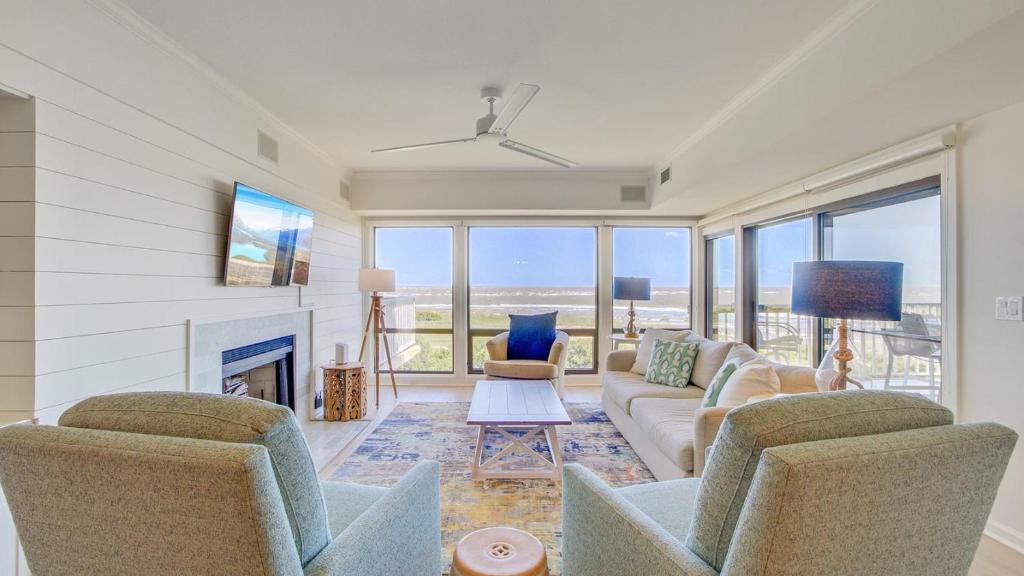 ein Wohnzimmer mit Sofa und Stühlen und einem Kamin in der Unterkunft 4407 Ocean Club by AvantStay Ocean Views w Community Pool Access - JanFeb Monthly Options Avail in Isle of Palms