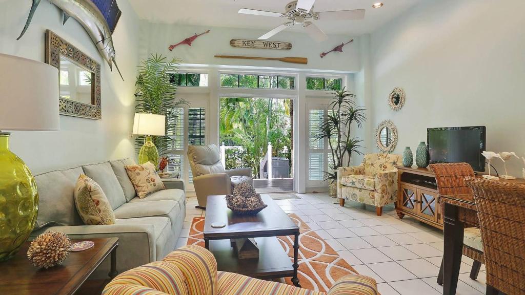 a living room with a couch and a tv at Key West Found by AvantStay Close to Shops w Patio Shared Pool Week Long Stays Only in Key West
