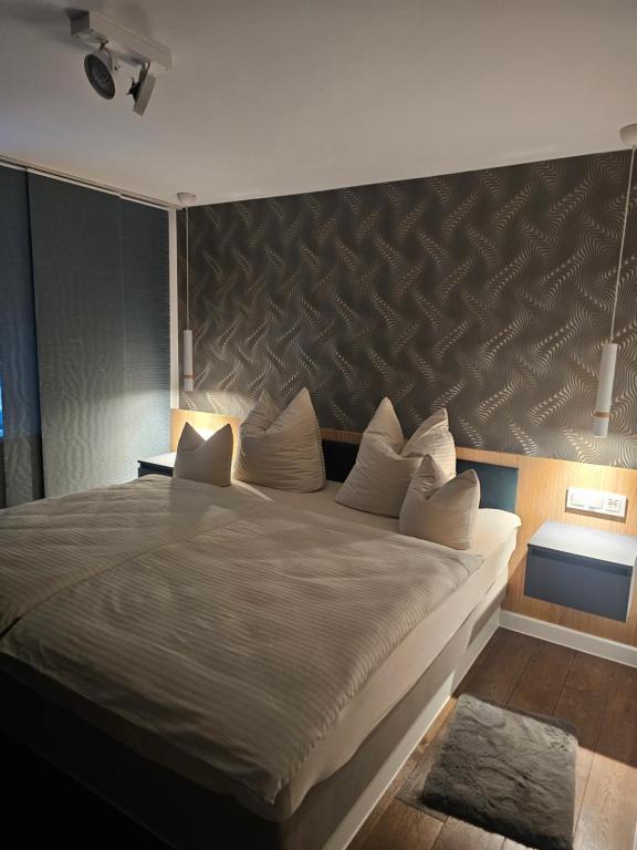 une chambre avec un grand lit avec une grande tête de lit dans l'établissement Costyn Apartments 1, à NuÃŸbaum