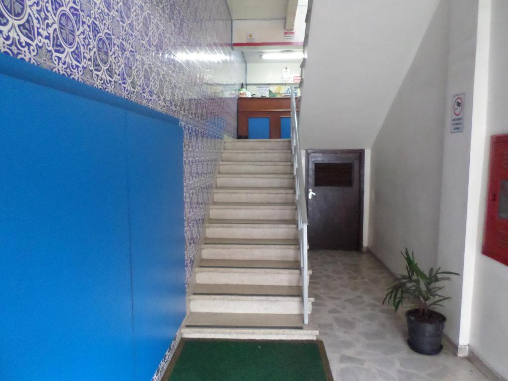 a staircase in an office building with a blue wall at Hotel Lisboa in Curitiba