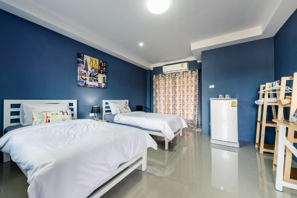 - une chambre avec 2 lits et un mur bleu dans l'établissement Sweet Dreams, à Phetchaburi