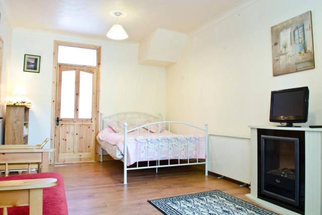a bedroom with a bed and a tv in a room at Cooraclare apartment in Cuar an Chláir