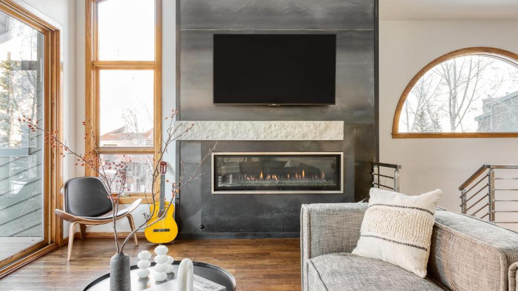un salon avec une cheminée avec une télévision au-dessus dans l'établissement Pandora by AvantStay Modern Mountain Escape in Great Location @ Entrance of Bear Creek Trail, à Telluride
