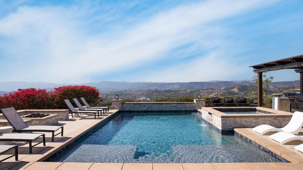 a swimming pool with chaise lounge chairs and a swimming poolvisorvisor at Camila by AvantStay 18-Person Temecula Mansion in Temecula