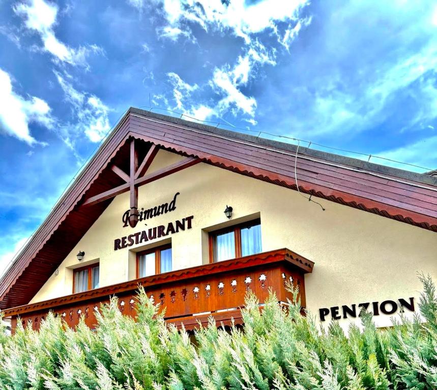 a building with a cross on the side of it at Penzion & Restaurant Raimund in Starý Smokovec
