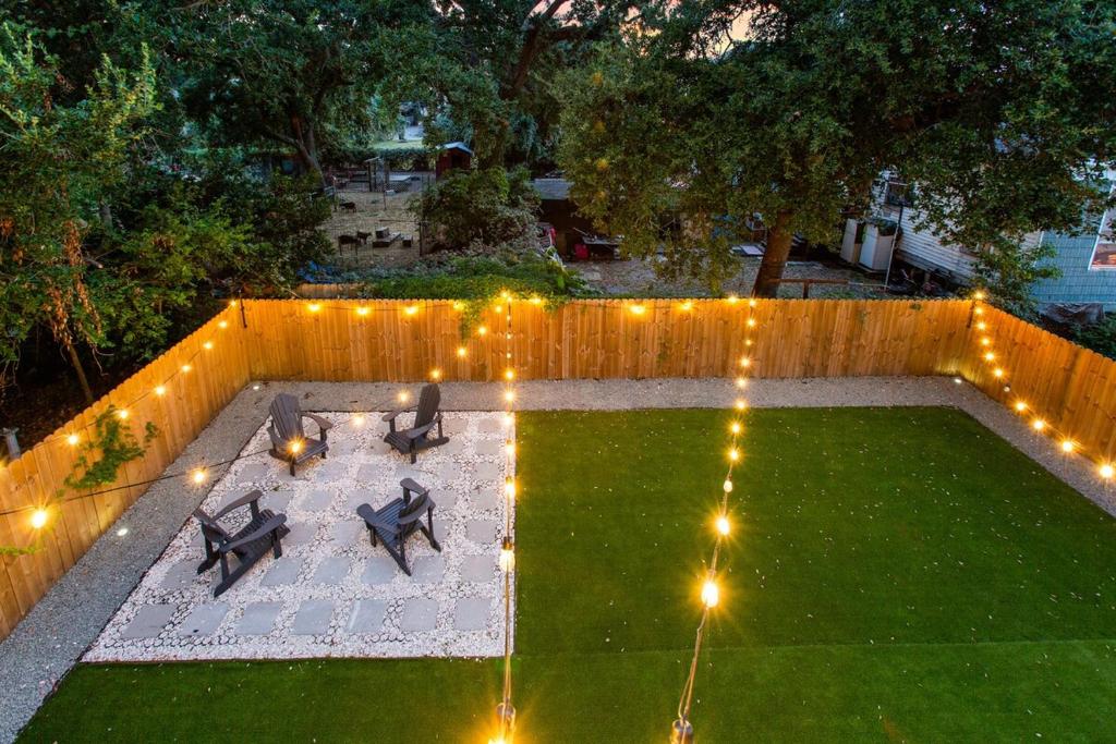 een achtertuin met een terras met twee stoelen en verlichting bij Beach House Fun! Sleeps the Whole Crew in Galveston