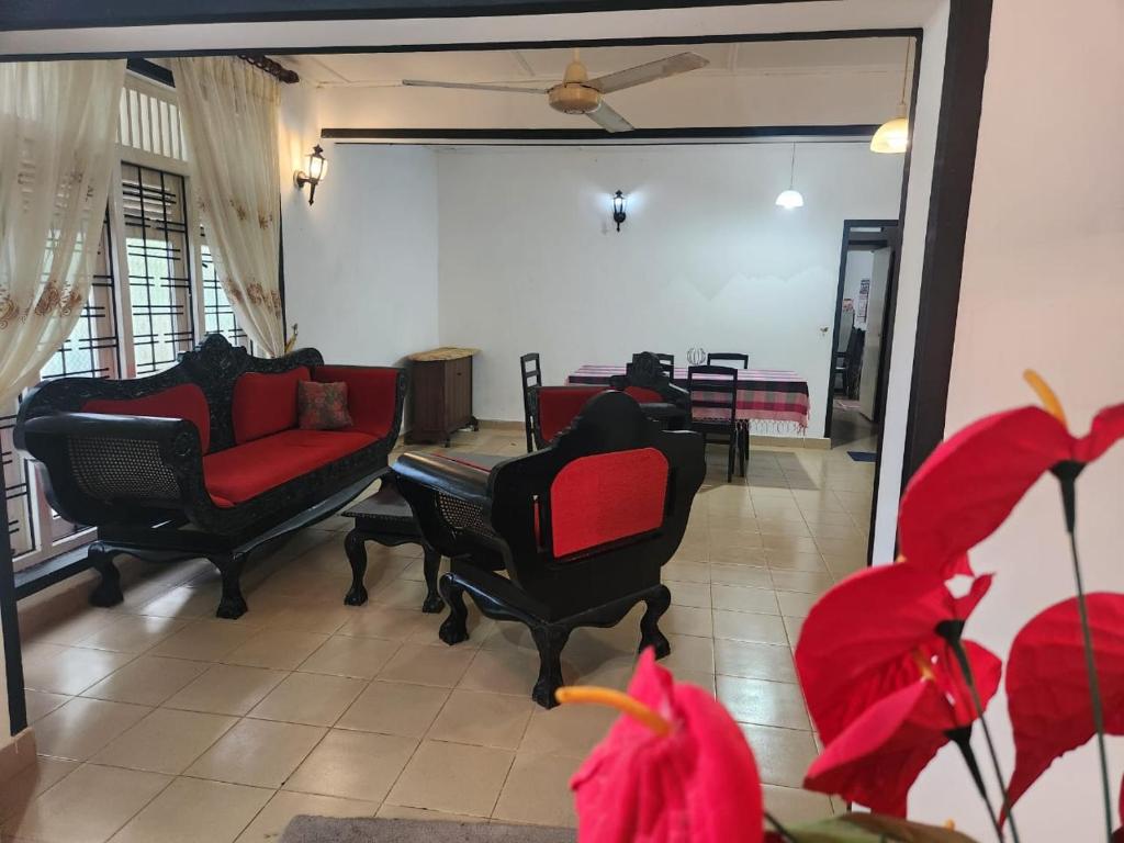 a living room with chairs and a couch and a table at Hansa Villa in Bentota