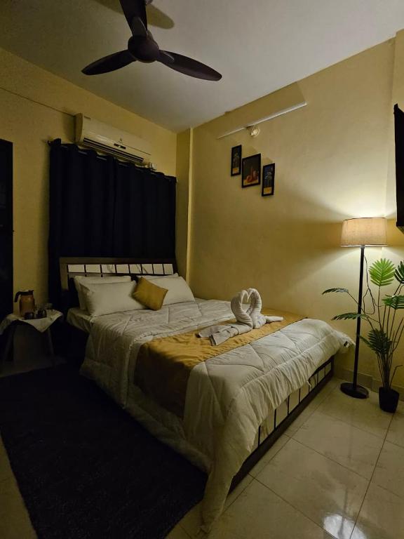 Un dormitorio con una cama grande con ventilador de techo. en Solitude Stays, en Pune