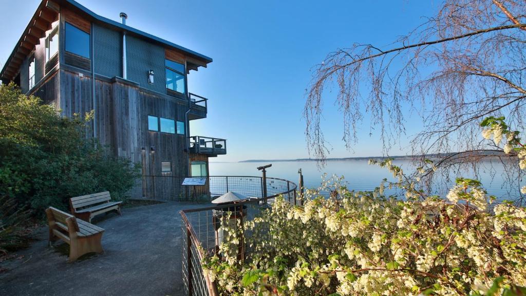 ein Haus mit einer Bank neben dem Wasser in der Unterkunft Langley Waterfront Condo by AvantStay A Views in Langley